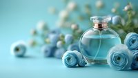 Elegant glass perfume bottle with blue roses and delicate white berries against turquoise background, creating soft romantic atmosphere for beauty and fragrance concepts.