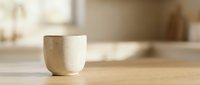 Minimalist ceramic cup with natural texture on wooden surface, suitable for home decor, kitchenware, and lifestyle design projects.