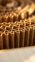 Corrugated cardboard sheets stacked in warehouse with warm lighting showing recycled packaging materials and sustainable shipping supplies for eco-friendly business.