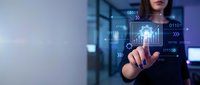 Woman in business attire interacting with digital holographic interface displaying binary code and data visualization in modern office environment for technology concepts.