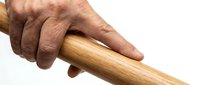 Senior man's weathered hand gripping wooden walking cane handle, elderly care and mobility assistance concept for healthcare and aging support materials.