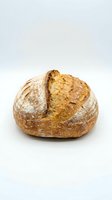 Freshly baked artisan sourdough loaf with crispy golden crust and flour dusting, isolated on white background for bakery, food, and culinary design use.