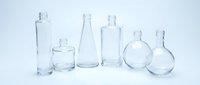 Empty clear glass bottles and containers of various shapes and sizes arranged on white background, isolated for product design and packaging concepts.