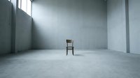 Wooden chair in empty concrete room with natural light from window, suitable for minimalist interior design and architectural visualization projects.