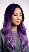 Young Asian woman with vibrant purple ombre hair and closed eyes wearing gray sweater against soft pink background for beauty and fashion concepts.