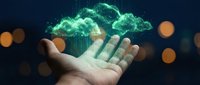 Digital cloud computing technology floating above open palm with glowing green data streams and bokeh lights on dark background for business concepts.