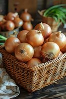 Fresh organic yellow onions in rustic wicker basket on wooden table. Natural food photography with soft lighting perfect for farm-to-table, cooking, or healthy lifestyle content.