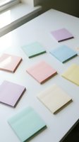 Colorful pastel sticky note pads arranged on a white desk near a window, perfect for office organization and productivity concepts.