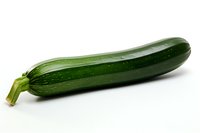 Fresh green zucchini squash isolated on white background, showing natural texture and glossy skin. For cooking, food blogs and healthy eating concepts.