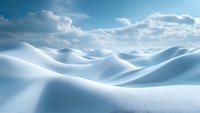 Pristine snow covered hills create smooth curves and shadows under bright winter sunlight and scattered clouds in blue sky, offering serene arctic landscape.