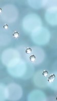 Sparkling diamonds floating on soft blue bokeh background with light reflections for luxury jewelry and wedding designs.