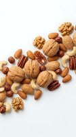 Mixed nuts collection with walnuts, almonds, cashews, pecans and hazelnuts scattered on white background for healthy snacking and cooking recipes.