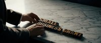 Businessman arranging wooden blocks spelling Small Business Grant on marble surface, symbolizing entrepreneurship, funding, and financial support concepts.