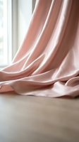 Soft pink curtains draped elegantly by window creating gentle folds and shadows in minimalist interior design for home decor and textile concepts.