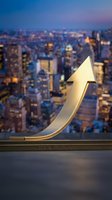 Golden upward arrow symbolizing business growth and financial success against illuminated cityscape at dusk, representing economic triumph and market expansion.