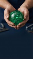 Male hands holding glowing green sphere with circuit board pattern inside, representing technology innovation, digital transformation, and sustainable business solutions for corporate presentations.