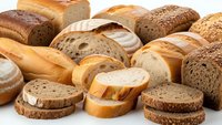 Fresh assorted bread loaves and slices including whole grain, white, and artisan varieties arranged on white background for bakery and food concepts.