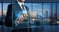 Professional businessman in suit interacting with futuristic holographic interface displaying business analytics icons in modern office environment.
