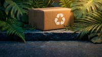 Eco-friendly cardboard package with recycling symbol surrounded by lush green tropical plants on natural stone surface for sustainable shipping solutions.