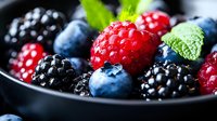 Fresh mixed berries including raspberries, blackberries and blueberries in dark bowl. Use for food, nutrition, healthy eating and recipe content.