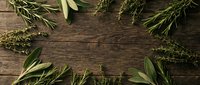 Fresh aromatic herbs frame rustic wooden background with sage, rosemary and bay leaves creating natural border for culinary cooking design projects.