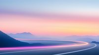 Curved mountain road with light trails at sunset, purple and orange sky creates dreamy atmosphere. Long exposure captures glowing vehicle lights along winding highway.