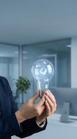 Businessman holding transparent lightbulb with floating business icons in modern office representing innovation and creative solutions for corporate growth.