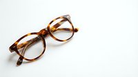 Stylish tortoiseshell eyeglasses with round frames isolated on white background for fashion and optical design projects.
