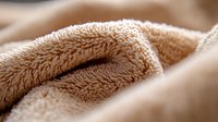 Soft beige microfiber texture close up with folds and wrinkles showing plush fabric detail and gentle shadows in warm neutral tones for background or textile design.