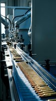 Automated ammunition production line with brass cartridges moving through industrial manufacturing equipment in modern factory facility.