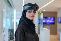 Woman wearing black hijab and futuristic augmented reality headset in modern tech environment, representing innovation in Muslim professional settings.