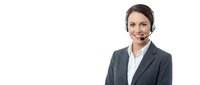 Professional female customer service representative with headset smiling in business suit on white background for corporate communications and support.