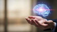 Businessman hand holding glowing digital brain hologram with neural networks and light effects representing artificial intelligence and innovation.