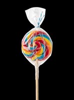 Rainbow swirl lollipop in clear wrapper isolated on transparent background, ready for stickers, t-shirt design, clipart, and print on demand use.