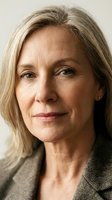 Mature woman with shoulder-length blonde hair and fair complexion wearing neutral blazer. Professional headshot suitable for corporate, business, and editorial use.