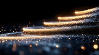 Magical glowing light trails with sparkling particles and bokeh effects against dark background create atmospheric festive mood for holiday designs.