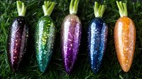 Colorful glitter carrots arranged in rainbow order on green grass background. Sparkly decorative vegetables create magical garden atmosphere for festive celebrations.