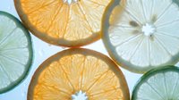 Fresh citrus slices including orange and lime rounds with visible pulp and seeds, perfect for food photography, beverage styling, and healthy lifestyle content.
