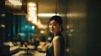 Elegant Asian woman in black dress at upscale restaurant bar, sophisticated dining atmosphere with warm lighting and modern interior design for hospitality marketing.