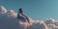 African American man sitting peacefully on fluffy white clouds against blue sky background for meditation and mindfulness concepts.