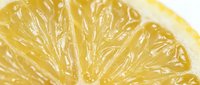 Macro shot of a fresh lemon slice showing juicy pulp texture, vibrant yellow color, and glistening citrus segments for food and beverage design.