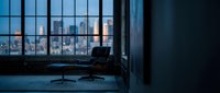 Modern office interior with empty workspace and city skyline view through floor-to-ceiling windows at dusk, suitable for corporate and business design projects.