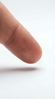 Close-up macro shot of human fingertip showing detailed fingerprint ridges and skin texture on clean white background for identity and security concepts.