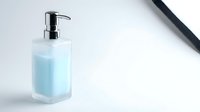 Modern glass soap dispenser with blue liquid on clean white surface for bathroom and kitchen hygiene products.