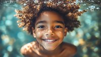 Young African American child with natural curly hair smiling brightly against blurred turquoise bokeh background, showing genuine happiness and innocence in close-up portrait.