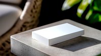 White rectangular box casting shadow on concrete surface with blurred natural background elements and soft lighting for minimalist product presentation.