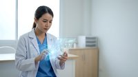 Young Asian female doctor in white coat using futuristic holographic medical technology interface in modern hospital office for healthcare innovation.