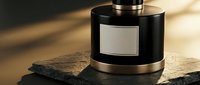 Luxury black cologne bottle with metallic accents on stone surface in warm lighting for masculine fragrance and perfume advertising campaigns.