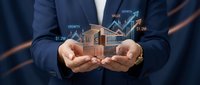 Businessman in navy suit holding virtual house model with rising financial graphs and growth arrows, representing real estate investment success and property market analysis.