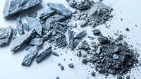Crushed charcoal and coal fragments scattered on white background, showing texture and particles for industrial, art, and design projects.